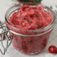 Cranberry sugar scrub in a glass jar with the lid open.