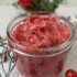 Cranberry sugar scrub in a glass jar with the lid open.