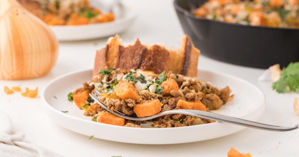 White plate with sweet potato and ground turkey hash.