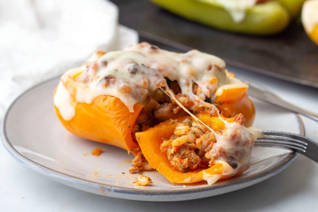 Stuffed orange bell peppers with ground turkey and barley with melted cheese on top