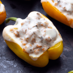 Yellow bell pepper stuffed with barley and ground turkey, with a piece of melted cheese on top.