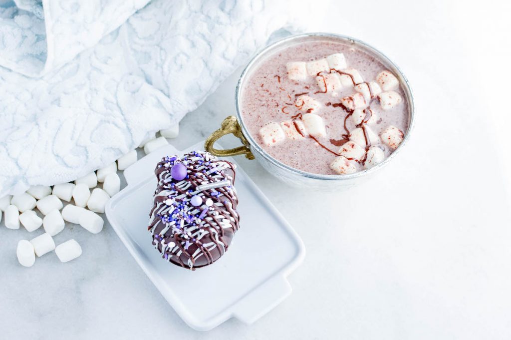 Easter Egg Hot Cocoa Bomb next to a cup of hot chocolate