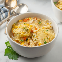 Chicken dumpling soup in a white bowl.