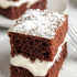 Closeup view of creamy marshmallow filling between two slices of devils food cake, with text naming the recipe a copycat Hostess Suzy Q.