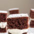 Closeup view of creamy marshmallow filling between two slices of devils food cake, with text naming the recipe a copycat Hostess Suzy Q.