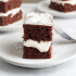 Closeup view of creamy marshmallow filling between two slices of devils food cake, with text naming the recipe a copycat Hostess Suzy Q.