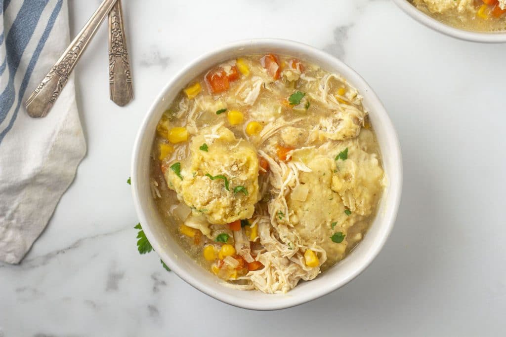 Chicken and dumpling soup in a white bowl.