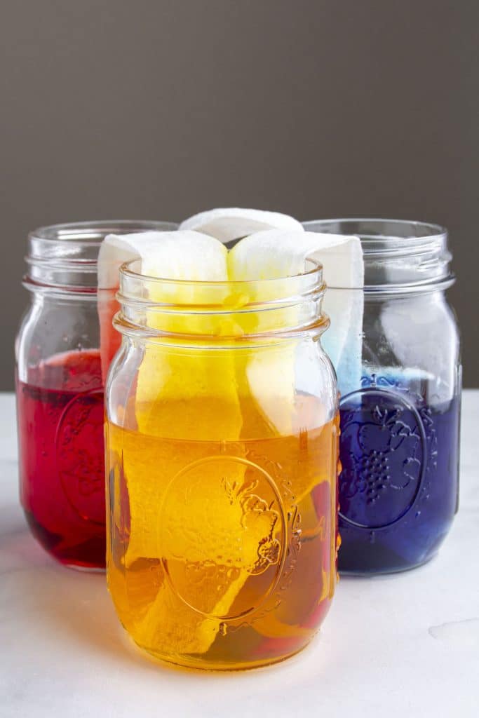 A photo of three colored liquids in three glass jars for the Walking Water Experiment.