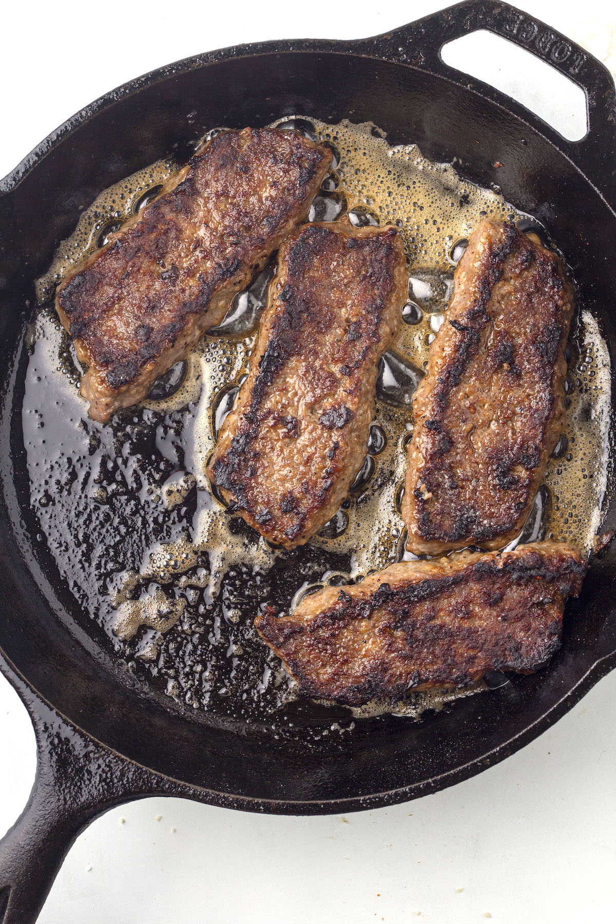 Fried slices of Scottish square sausage in a frying pan.
