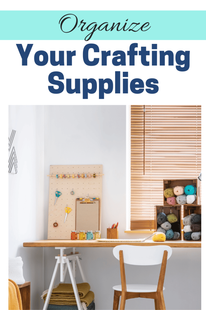 Table with boxes of neat yarn balls next to a pegboard with organized craft supplies.
