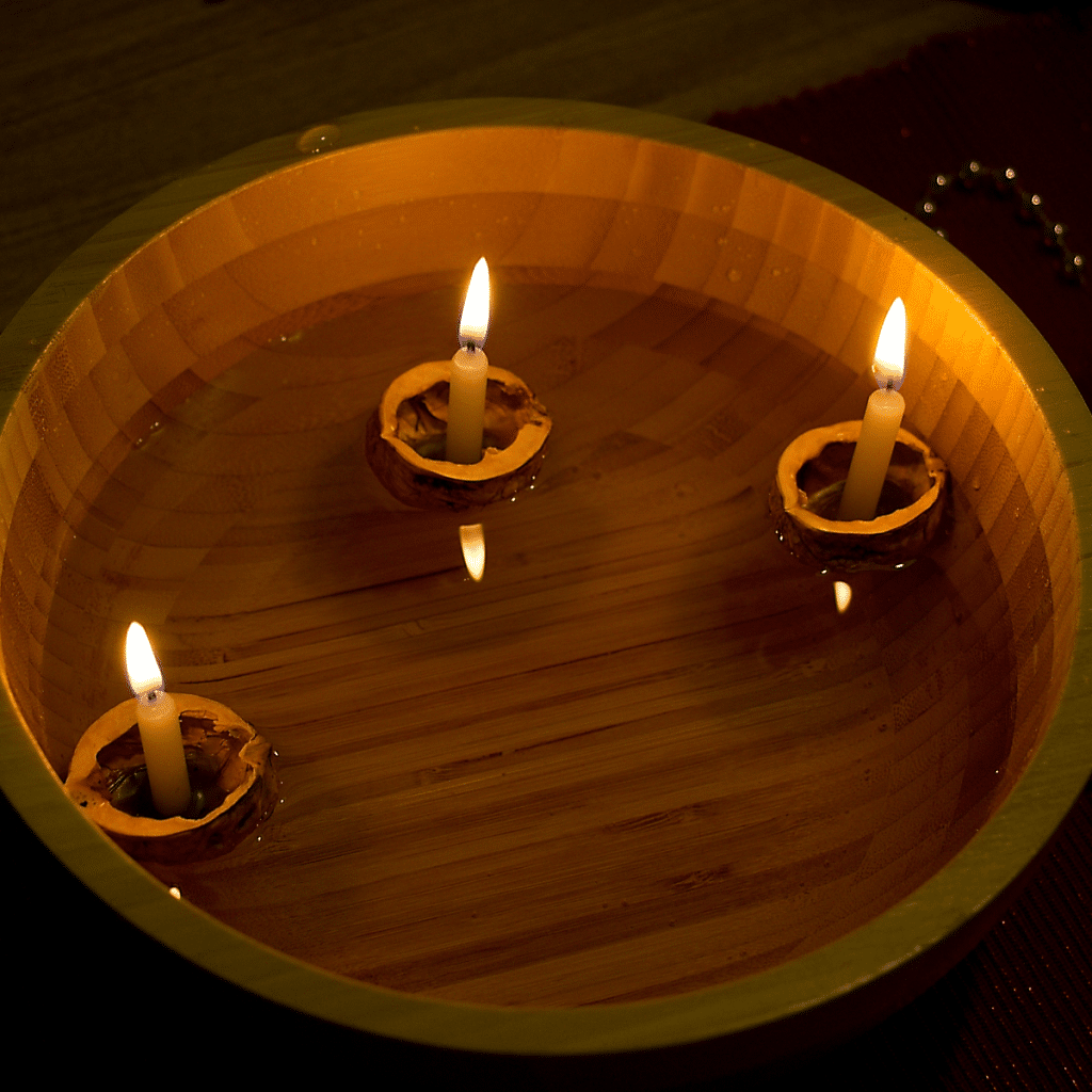 3 candles floating in a bowl of water.