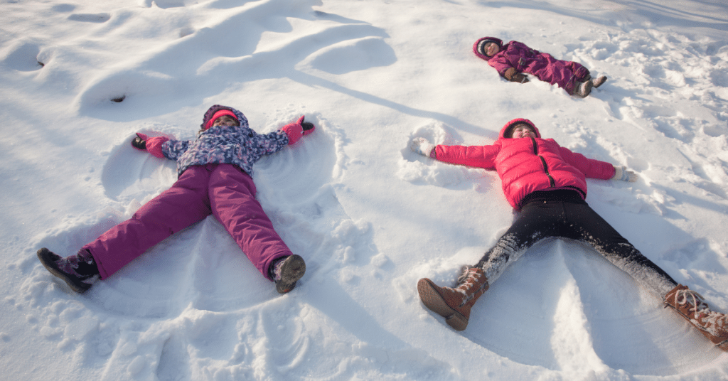 Three children making snow angels.