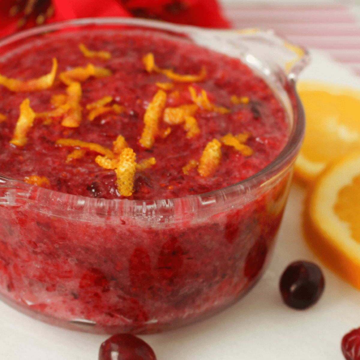 Closeup of a cranberry orange sugar scrub in a glass container.